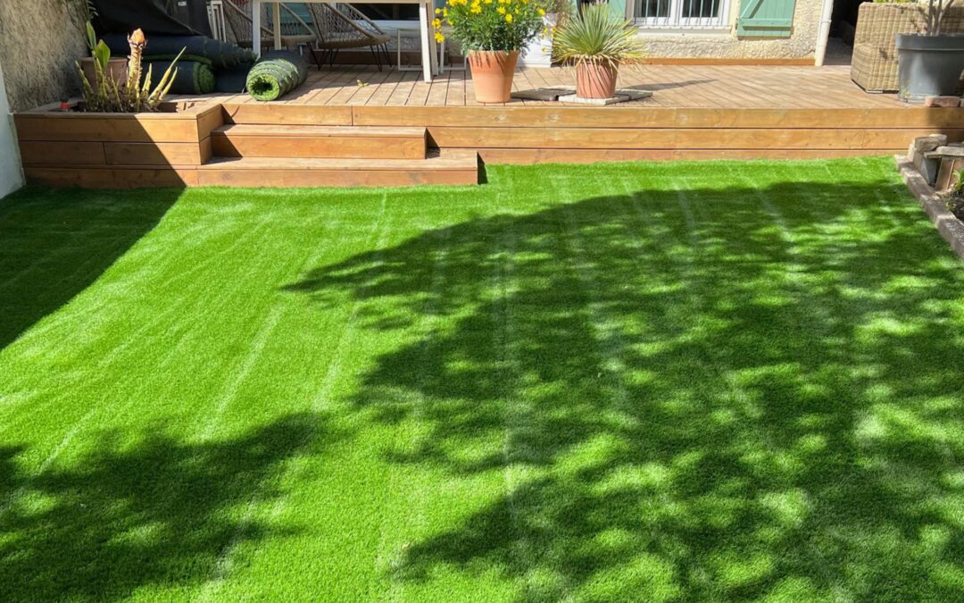 Image principale (jardin avec terrasse bois et façade aux volets bleu-vert) : pose-pelouse-synthetique-bentgrass-52mm-jardin-terrasse-bois-gard-yards